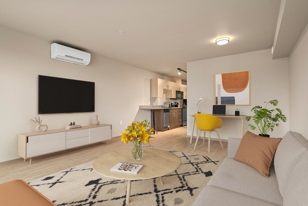 A living room with a grey couch, a coffee table, a yellow chair, a TV, and a potted plant.