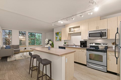 A kitchen with a bar area and a refrigerator.