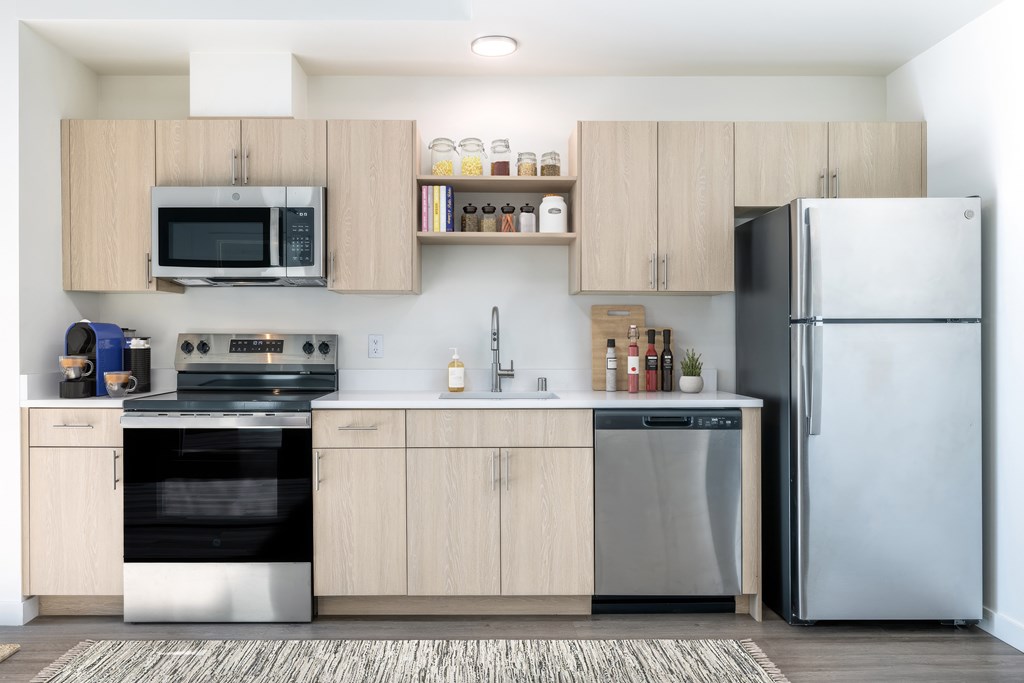 A modern kitchen with a refrigerator, oven, and microwave.