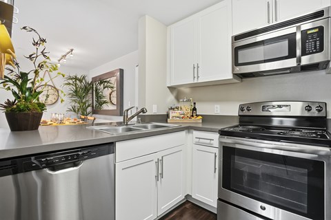 A modern kitchen with stainless steel appliances and white cabinets.
