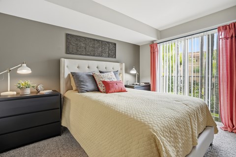 A bedroom with a large bed and a black dresser.