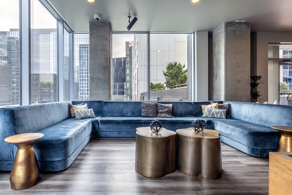 A modern living room with a blue sofa and gold side tables.