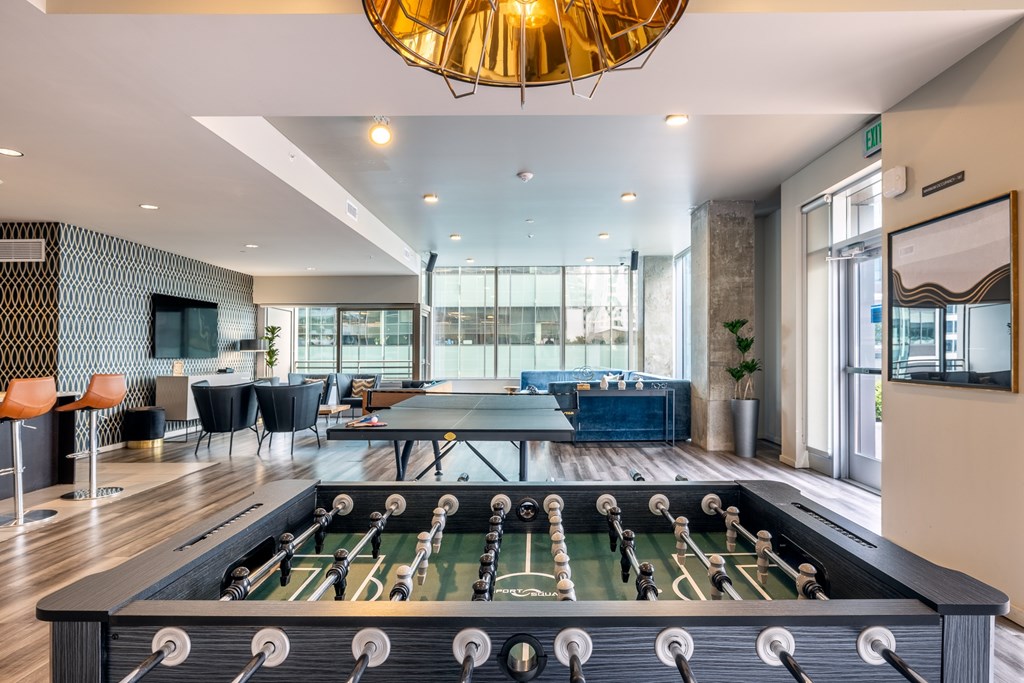 A foosball table is in the middle of a room with a couch and chairs.
