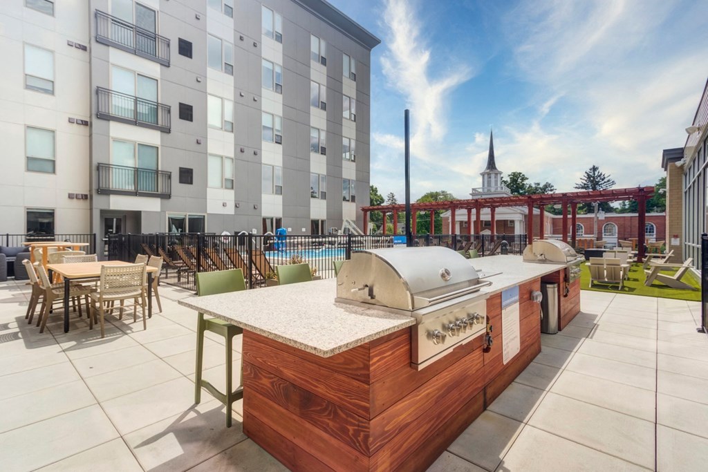 an outdoor patio with a grill and a table with chairs