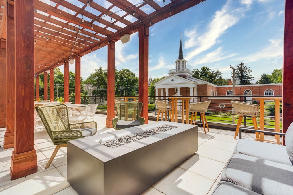 a patio with a table and chairs and a church in the background