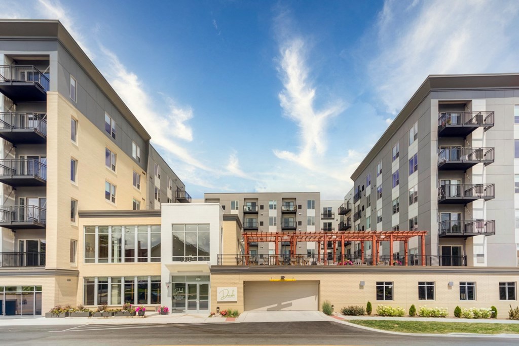 an exterior view of an apartment building with a street in front of it