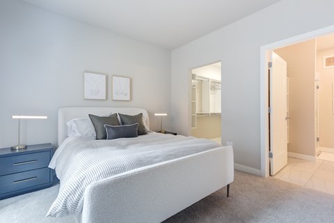 A bedroom with a large bed and two nightstands.