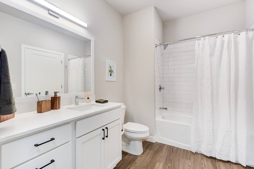 a bathroom with a large mirror and a toilet and a shower