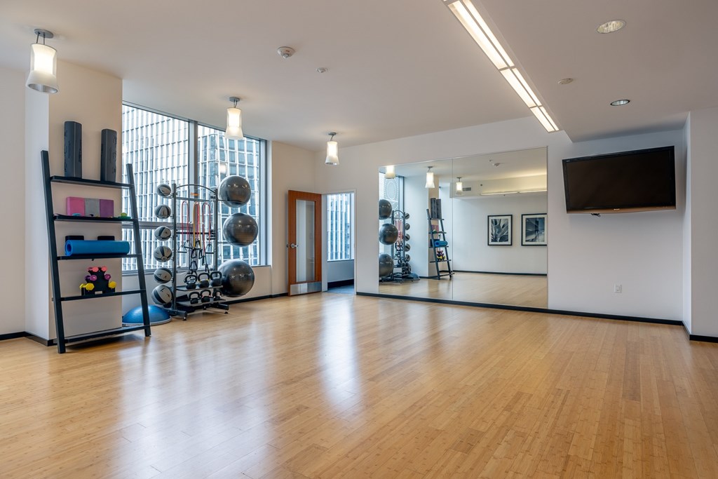 A gym with a mirror, weights, and exercise equipment.