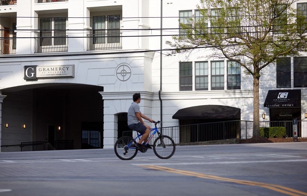 a man riding a bike down the street in front of a building