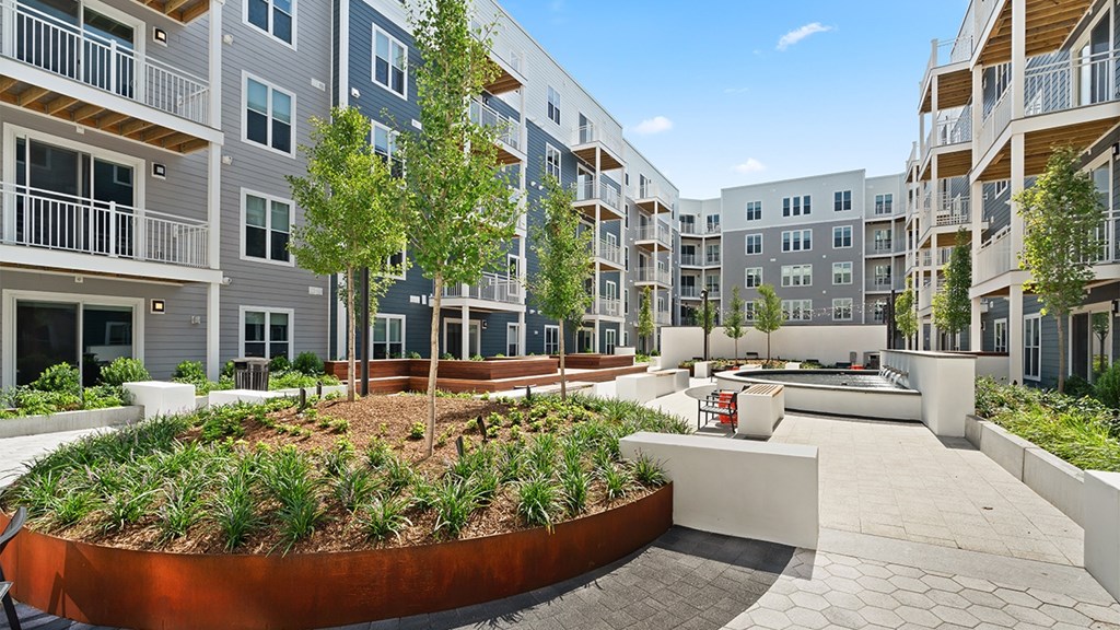 A modern apartment complex with a central courtyard and landscaping.