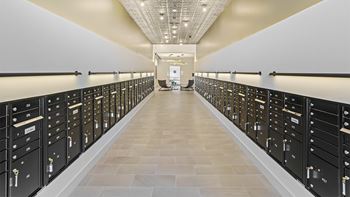 A long hallway with a row of black lockers on each side.