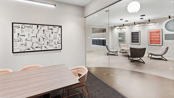 A modern conference room with a large table and chairs.