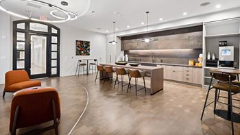 A modern kitchen with a curved wooden table and chairs.