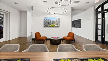 A modern waiting room with a large painting on the wall and comfortable seating.