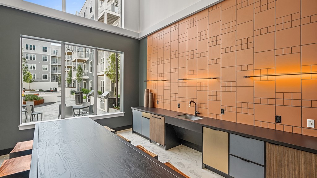A modern kitchen with a large island and a view of a courtyard.