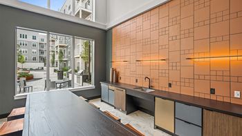 A modern kitchen with a large island and a view of a courtyard.