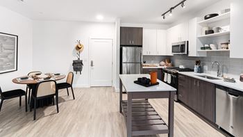 A modern kitchen with a dining table and chairs.
