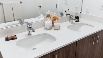 A bathroom with two sinks and a mirror.