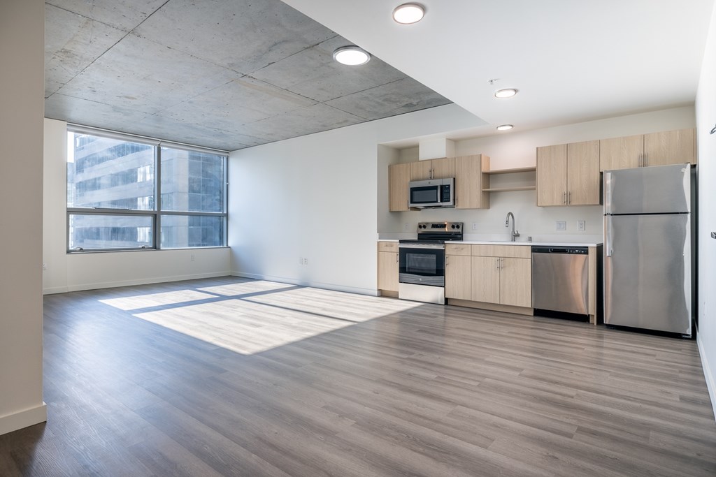 A kitchen with wooden floors and stainless steel appliances.