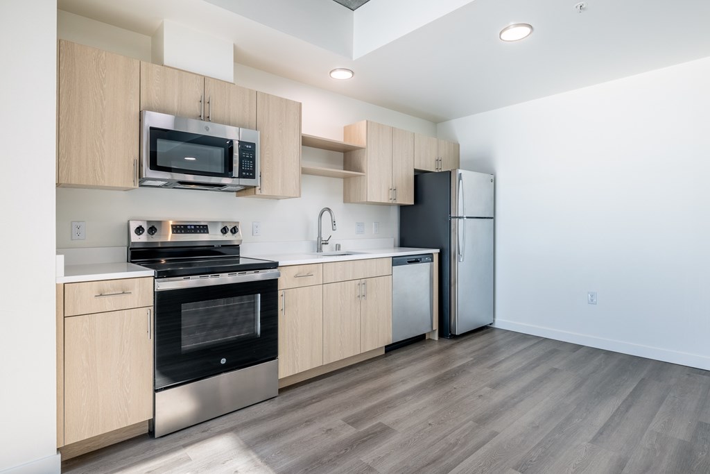 A kitchen with a stove, oven, microwave, and refrigerator.