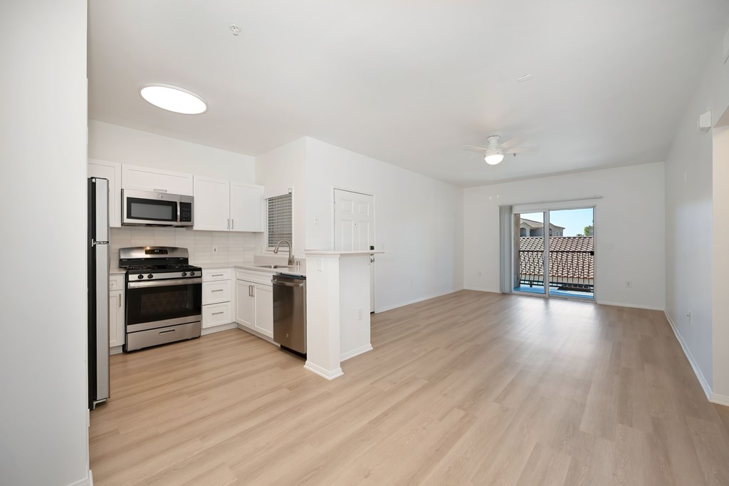 A kitchen with white cabinets and a black refrigerator.
