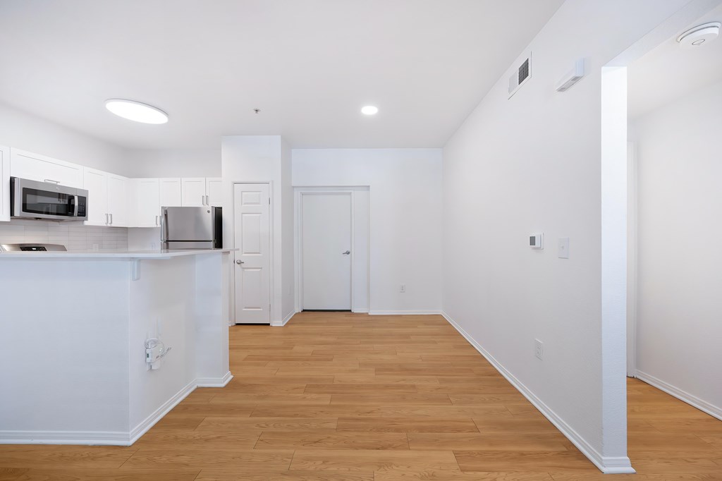 A kitchen with white cabinets and a microwave above the stove.