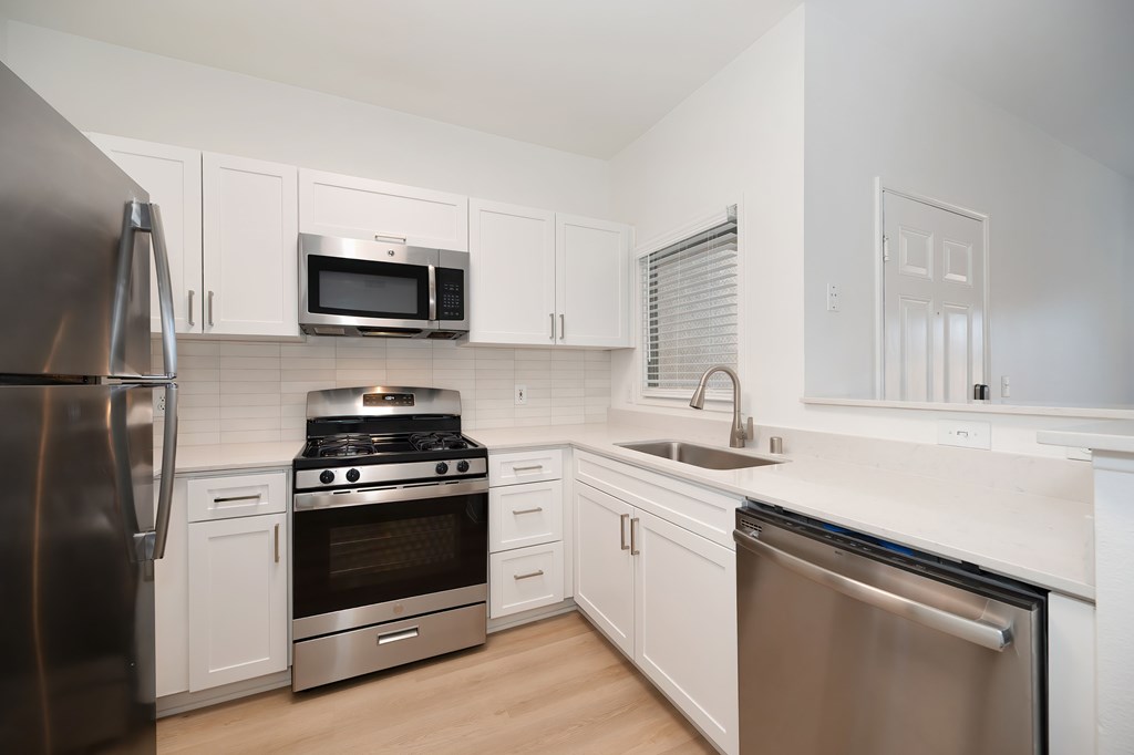 A kitchen with white cabinets and stainless steel appliances.