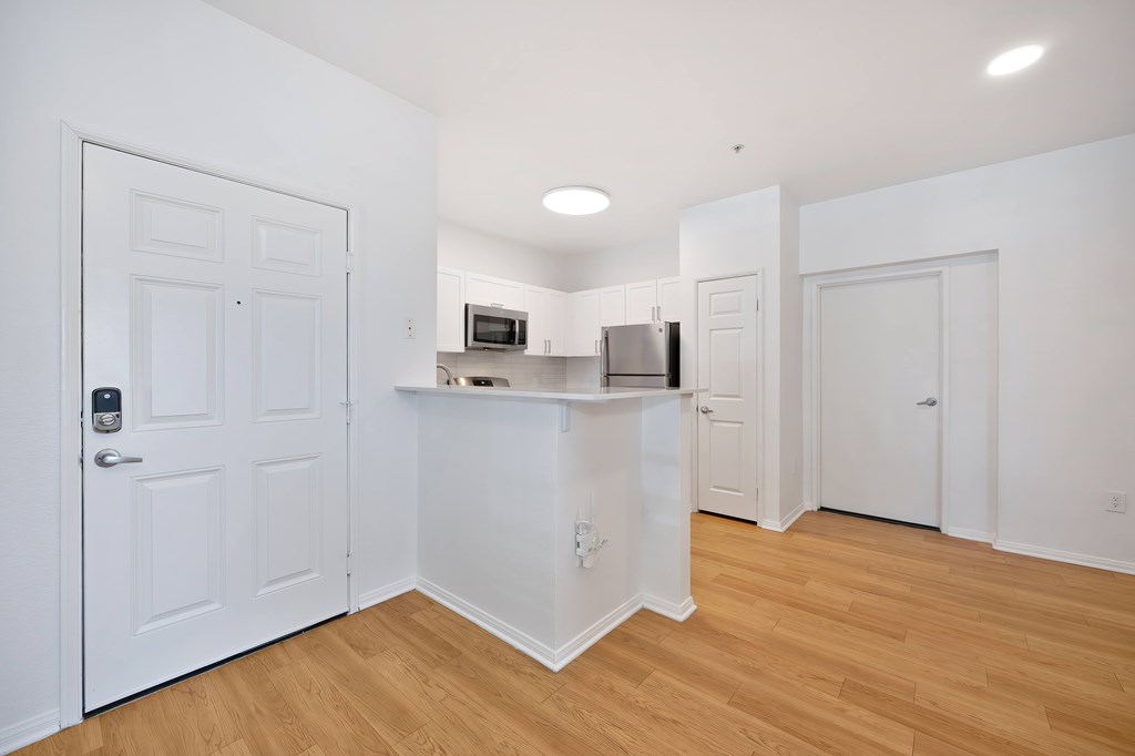 A kitchen with white cabinets and a refrigerator.