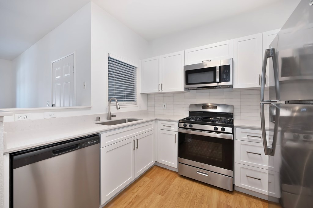 A modern kitchen with stainless steel appliances and white cabinetry.