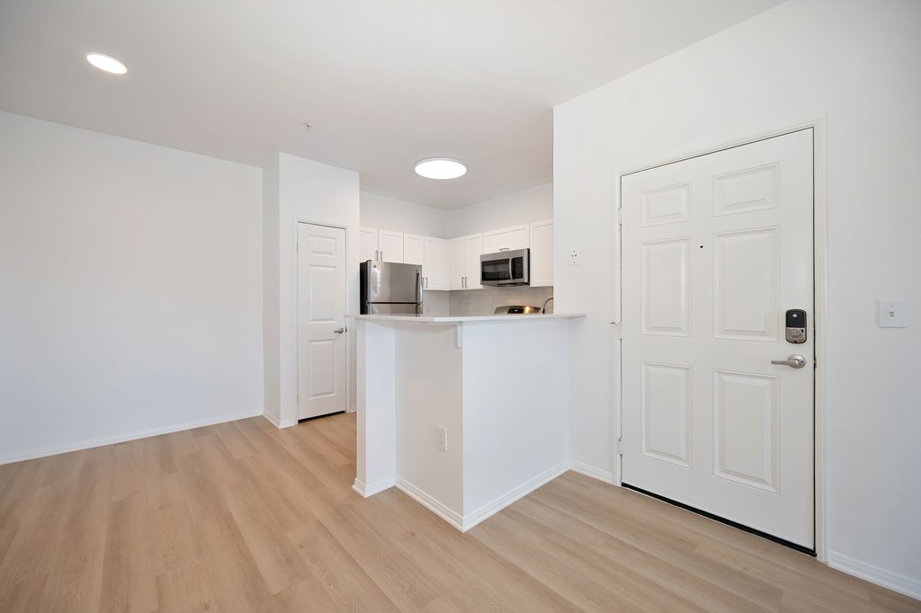 A kitchen with white cabinets and a refrigerator.