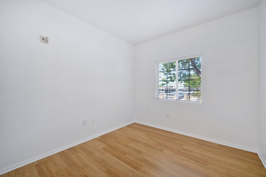 Empty room with wooden floor and a window.
