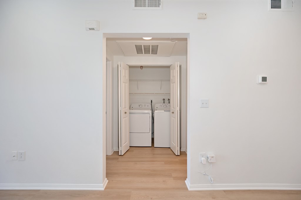 A white laundry room with a washer and dryer.