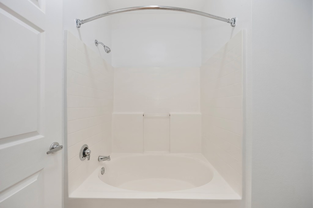 A white bathroom with a tub and shower.