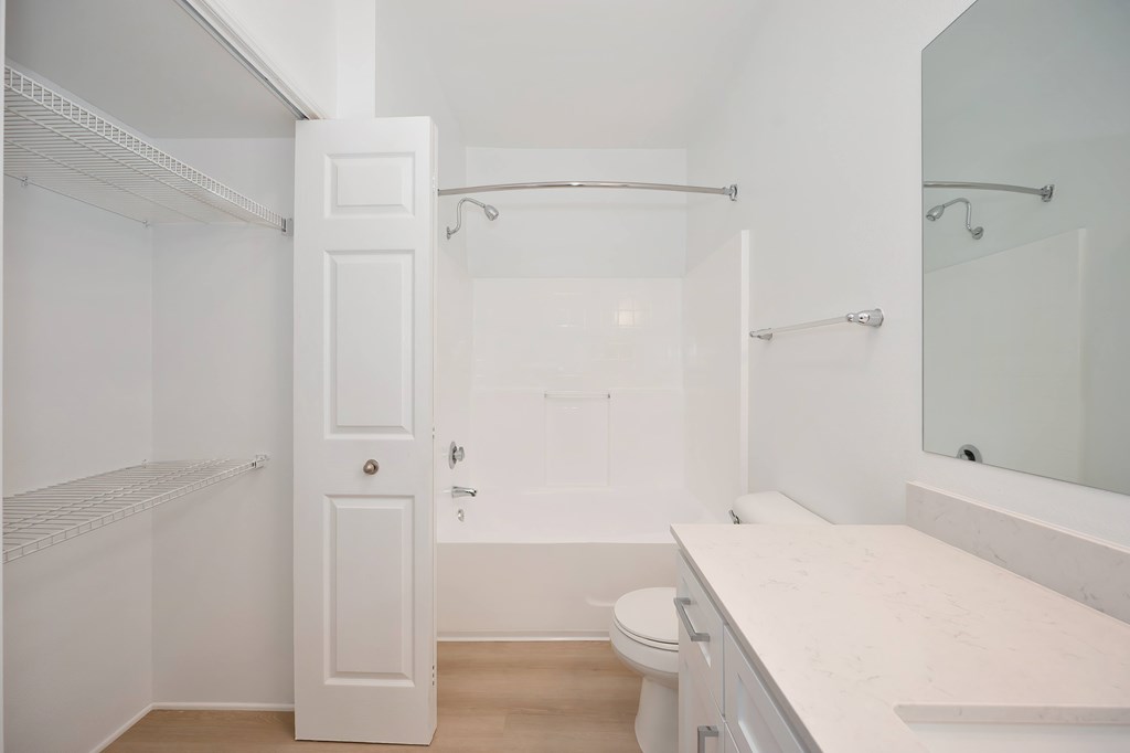 A white bathroom with a toilet, sink, and shower.