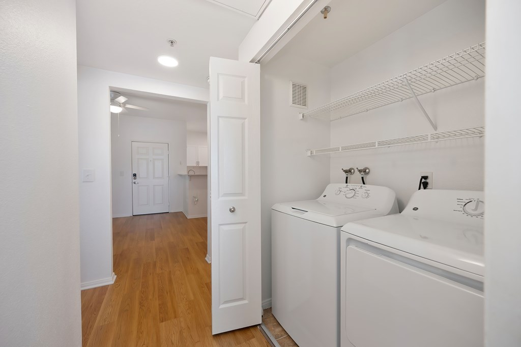 A white bathroom with a sink, toilet, and washing machine.