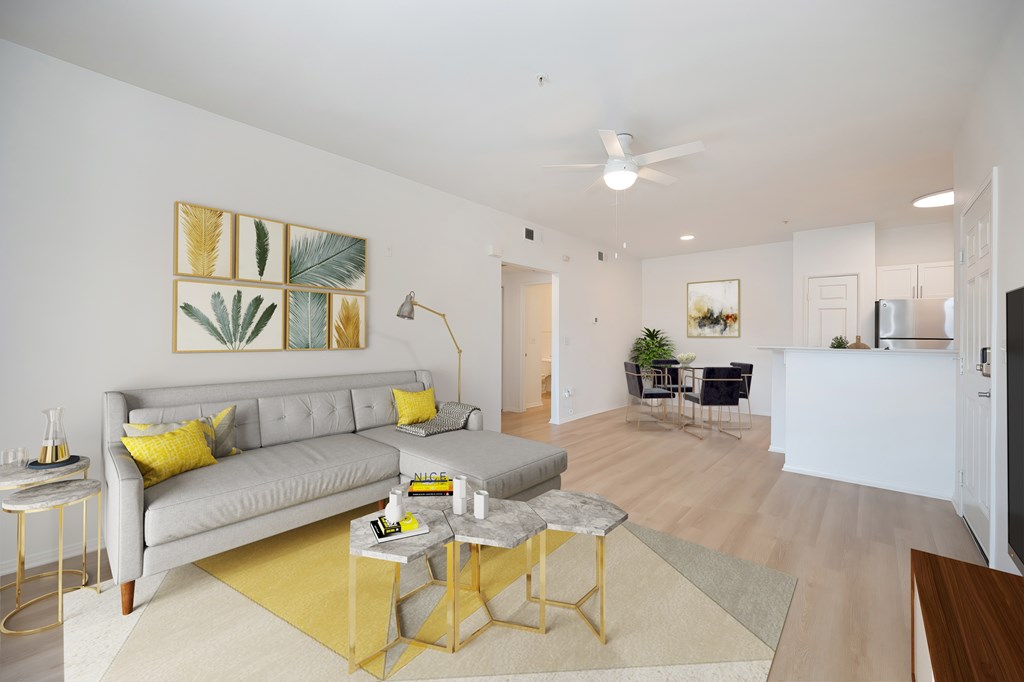 A living room with a grey couch, yellow pillows, and a yellow rug.