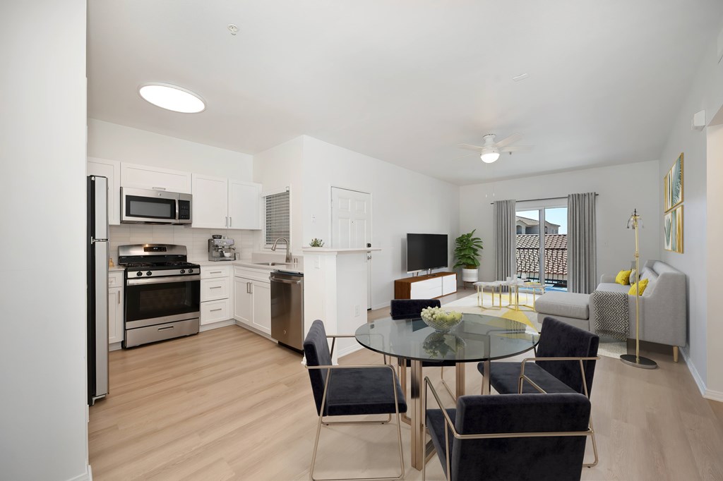 A modern kitchen with a glass table and chairs.