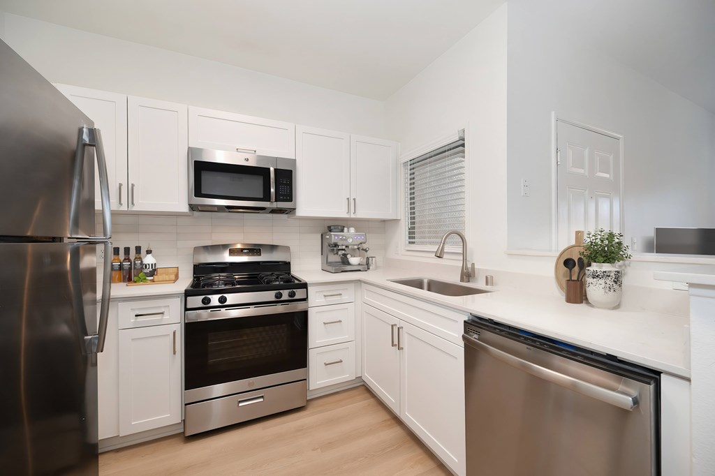 A modern kitchen with stainless steel appliances and white cabinets.