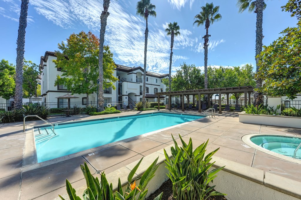 A swimming pool surrounded by palm trees and plants.
