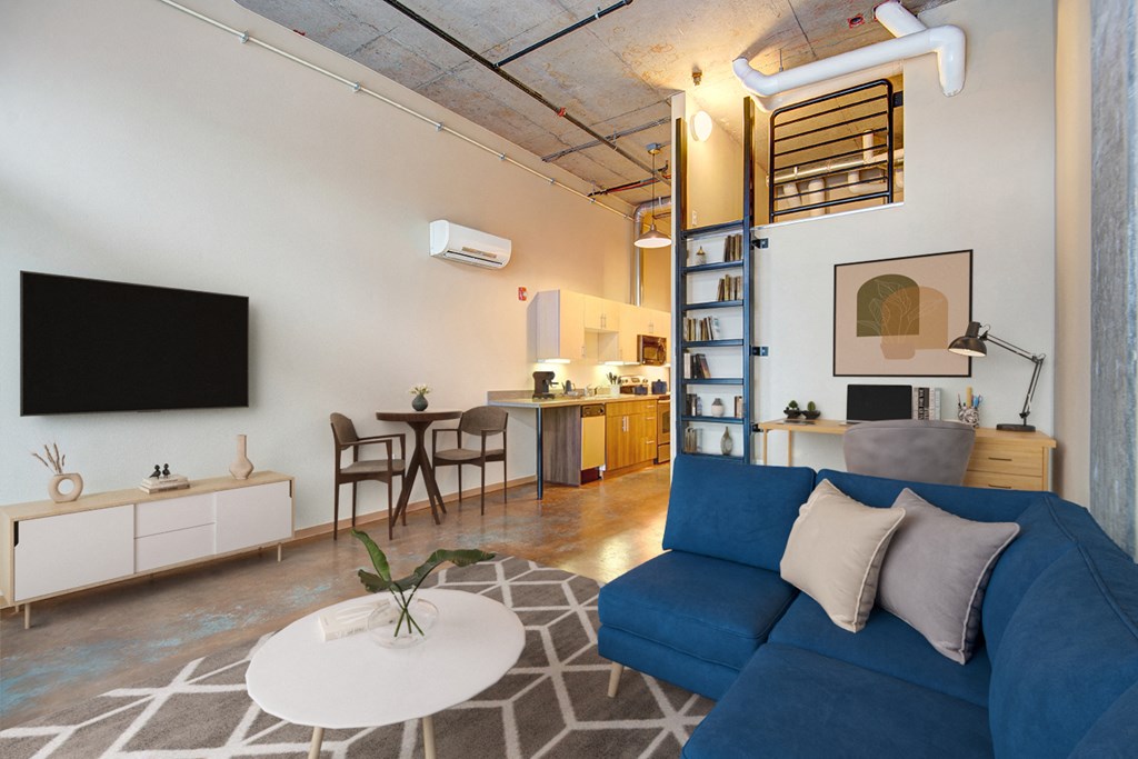 A living room with a blue couch and a television on the wall.