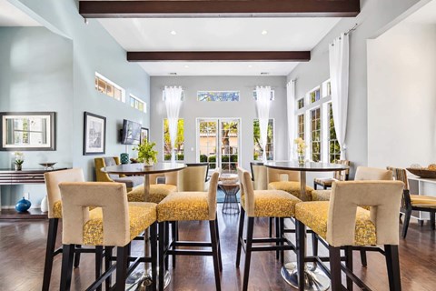 A dining room with a table surrounded by chairs.