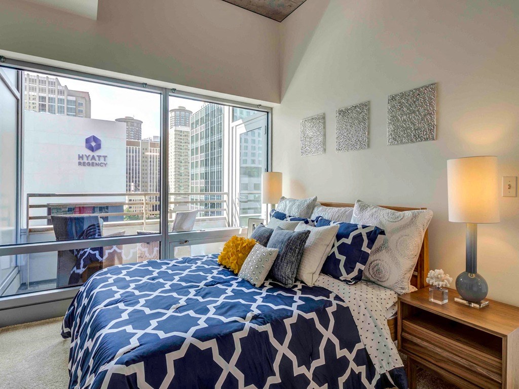 a bedroom with a bed and a large window