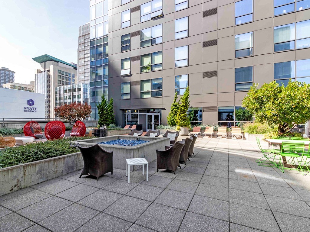 a patio with a table and chairs in front of a building