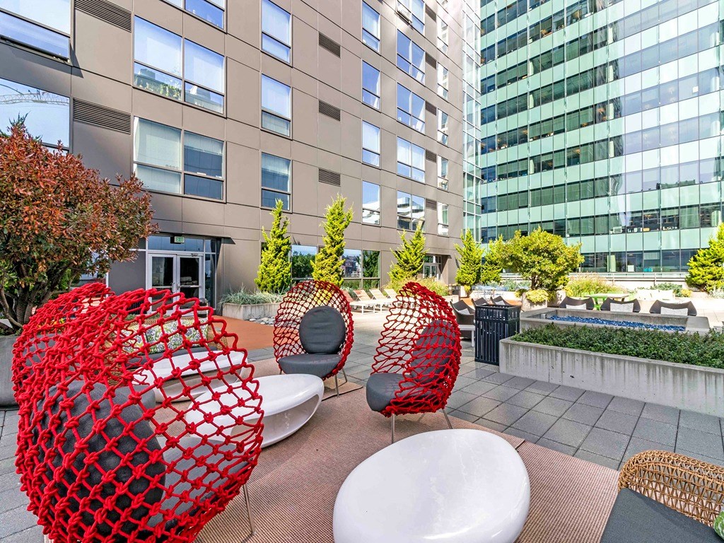 a group of chairs and tables in a courtyard with tall buildings