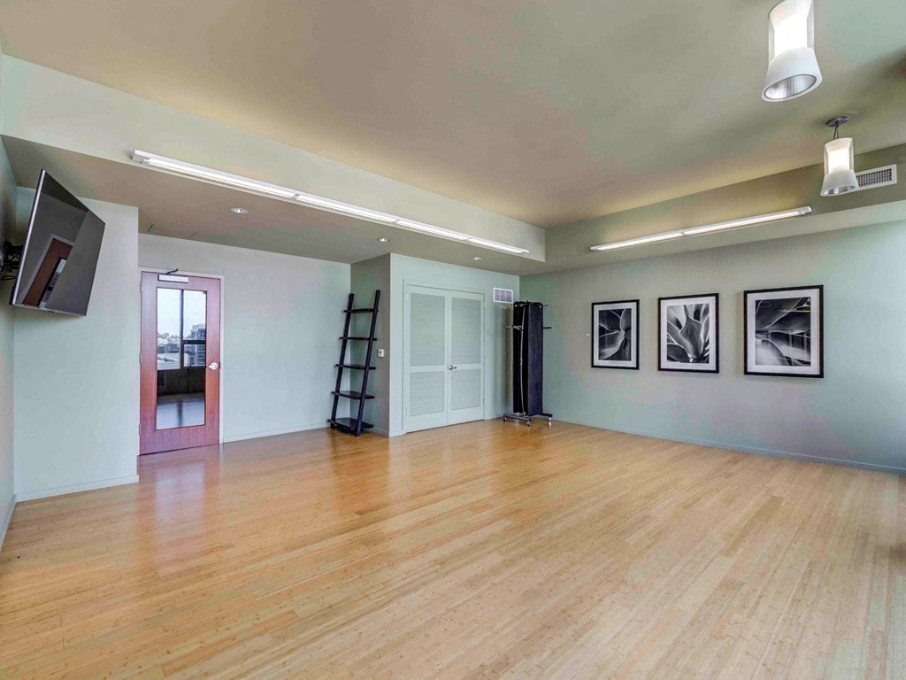 a living room with a wood floor and a ladder in the corner