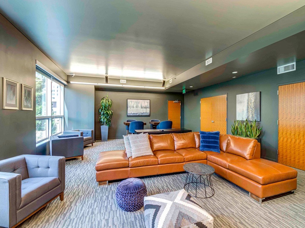 a large living room with leather couches and chairs
