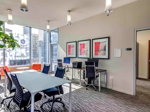 A conference room with a table, chairs, and framed pictures on the wall.