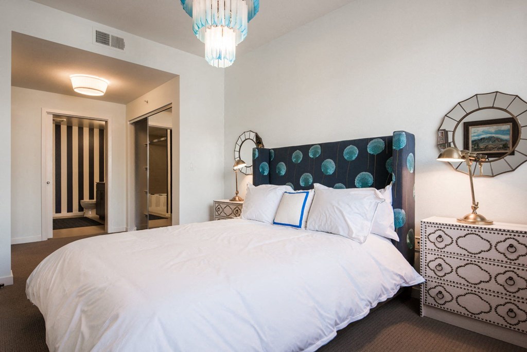 a bedroom with a large bed and a chandelier