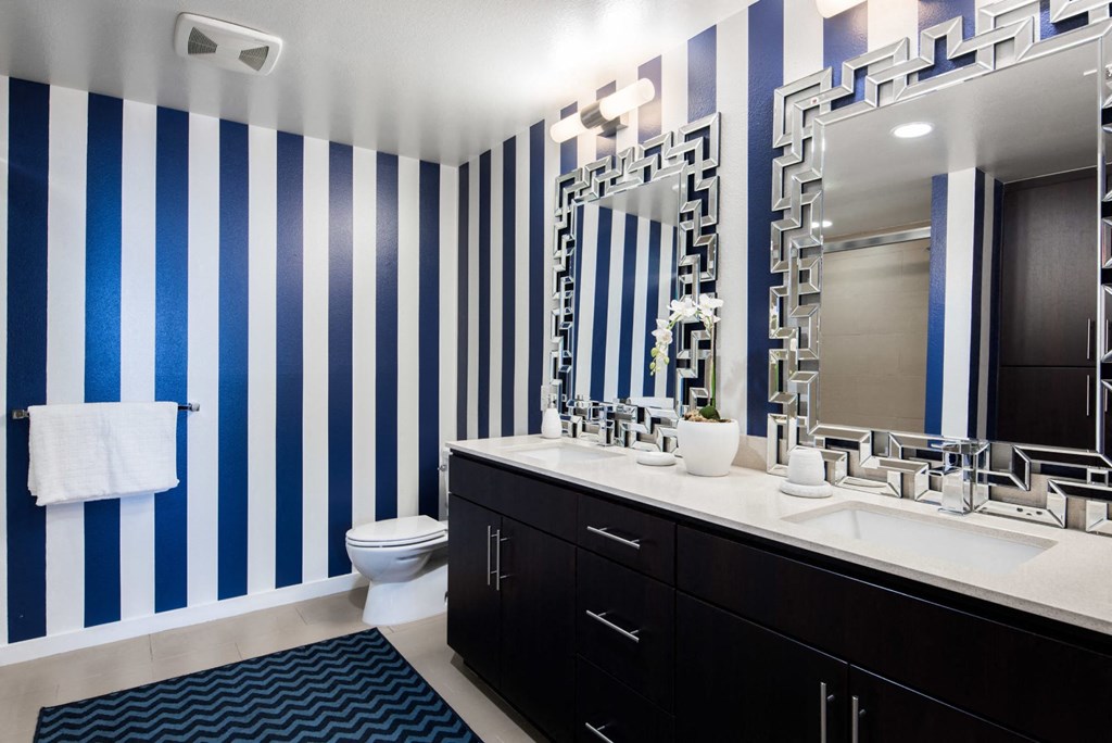 a bathroom with blue and white striped walls and a white toilet